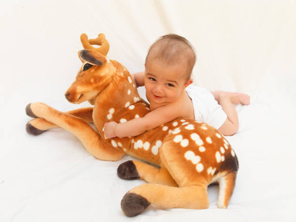 istock 4 months old baby boy playing with soft toy dear and chick 830859404