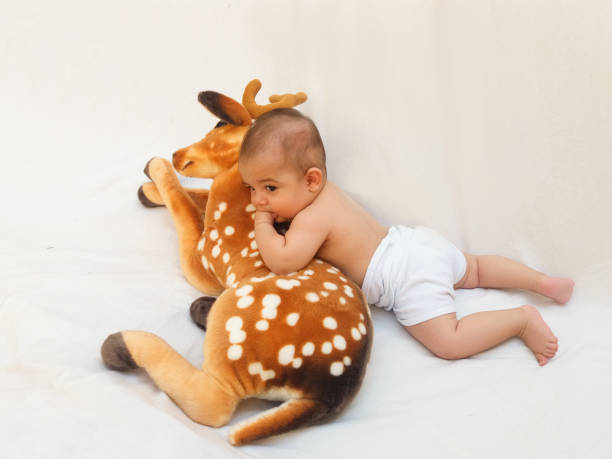 istock 4 months old baby boy playing with soft toy dear and chick 830862474
