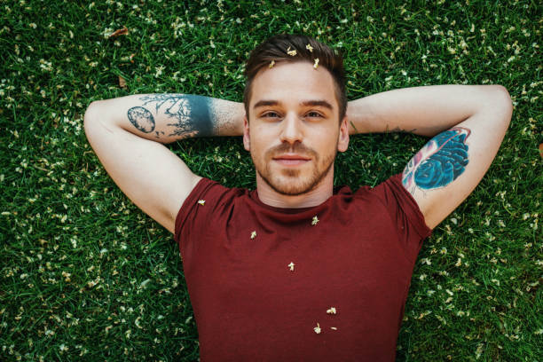 istock Pensive Eastern European young man relaxing in park on green grass 830862570