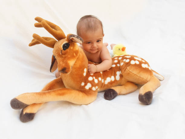 istock 4 months old baby boy playing with soft toy dear and chick 830862674