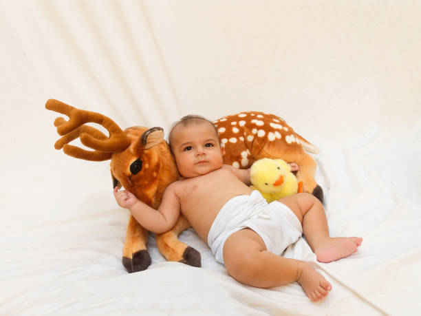 istock 4 months old baby boy playing with soft toy dear and chick 830863192