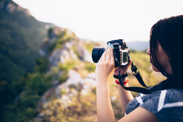 istock Young woman taking picture in the mountains 830866874