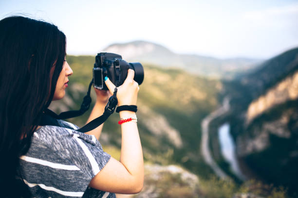 istock Young woman taking picture in the mountains 830867192