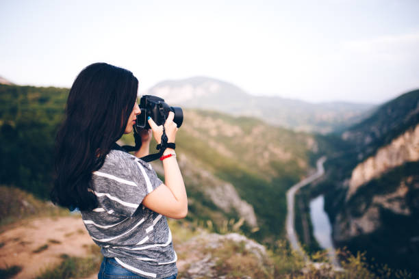 istock Young woman taking picture in the mountains 830867526