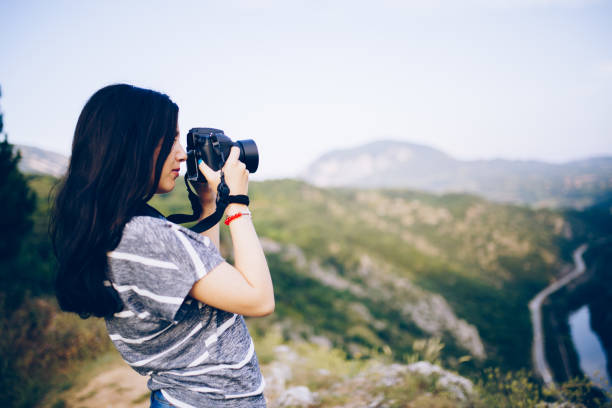 istock Young woman taking picture in the mountains 830867780