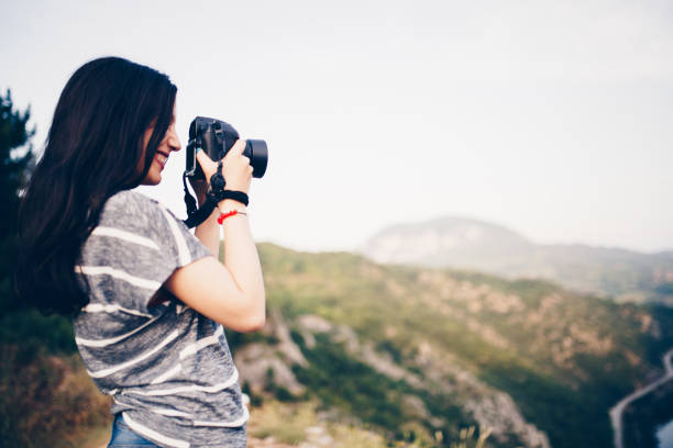 istock Young woman taking picture in the mountains 830868234