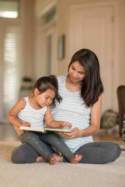 istock Pregnant mom reading to her daughter 830958732