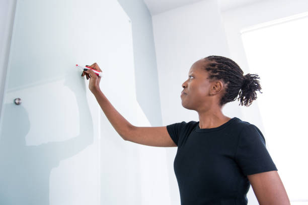 istock Businesswoman Writing on the Whiteboard 830979064