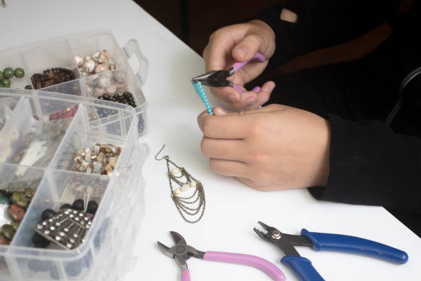 istock Person making jewelry with beads and other materials with tools 830981664