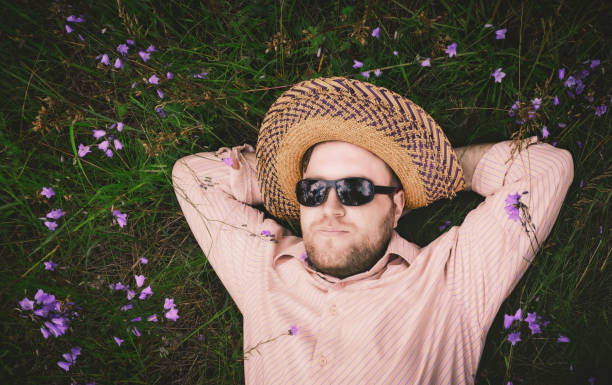 istock Man Rest On The Grass And Bellflowers 830992596