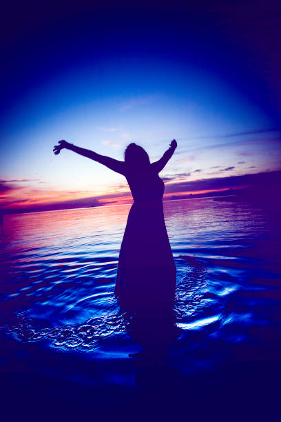 istock Woman Silhouette Dancing in Ocean Water 830998930