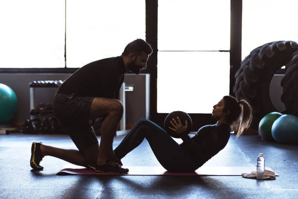 istock Cross Training Sit-ups with Medicine Ball in a Gym 831005438