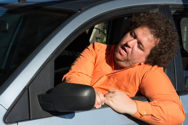 Funny man in the car. Street. Heat. A fat guy in a blue car. emergency room human head physical injury drunk stock pictures, royalty-free photos & images