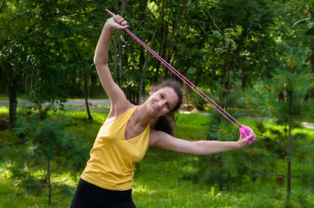 Girl is engaged fitness in park, exercise with skipping rope