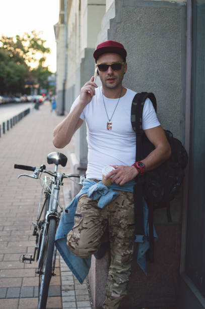 istock Handsome man with bike using smartphone 831016988