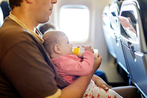 istock Father holding his baby daughter during flight on airplane going on vacations 831019710