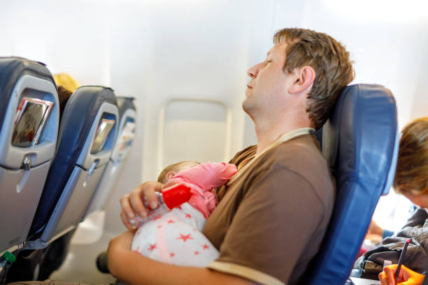 istock Young tired father and his baby daughter sleeping during flight on airplane going on vacations 831020142