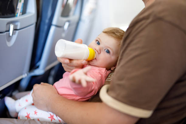 Pai, segurando sua filha bebê durante voo em avião passa férias - foto de acervo