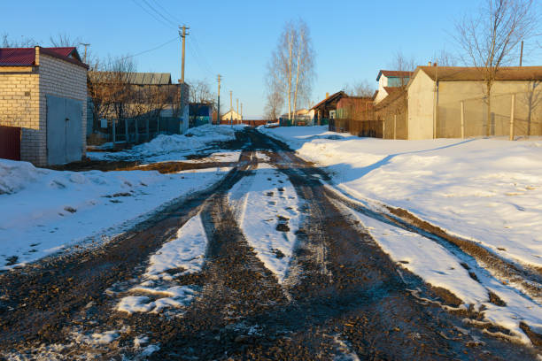 istock Spring slush in a village street with snow 831023388