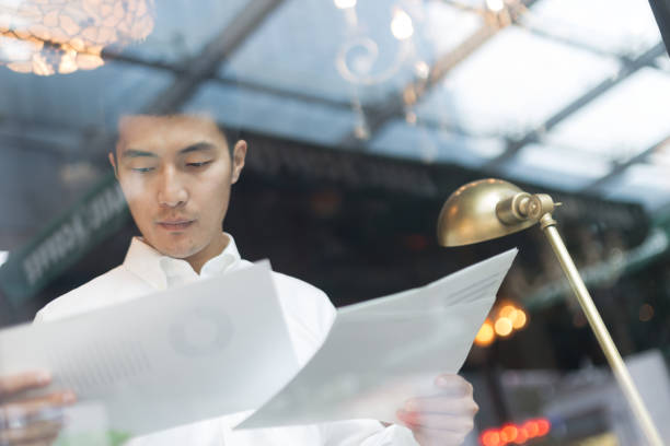 istock young asian man holds business report 831031550