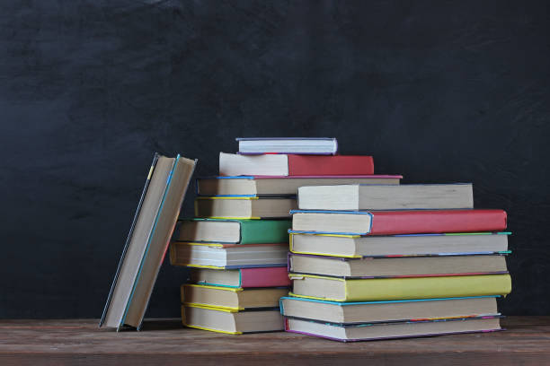 istock stack of books on the background of the school Board. 831031734