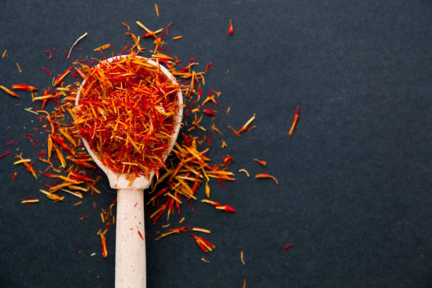 Saffron in a spoon on a dark background, selective focus, macro shot, shallow depth of field stock photo
