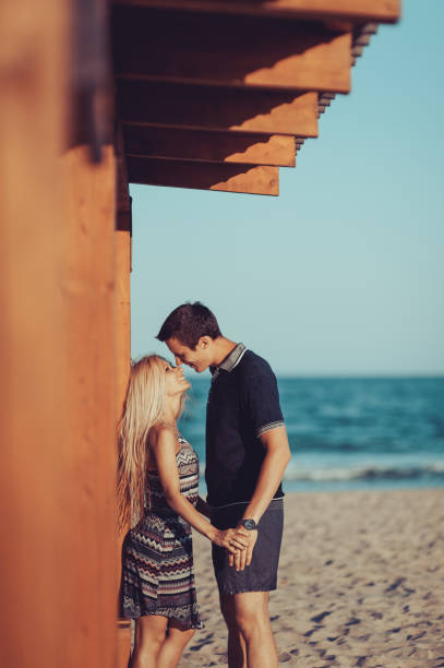 istock Young couple in love walking on the beach 831039126
