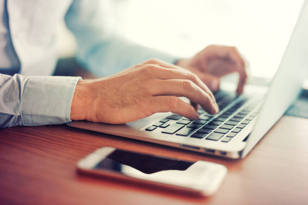 istock Close up of male hands using laptop at office 831039734