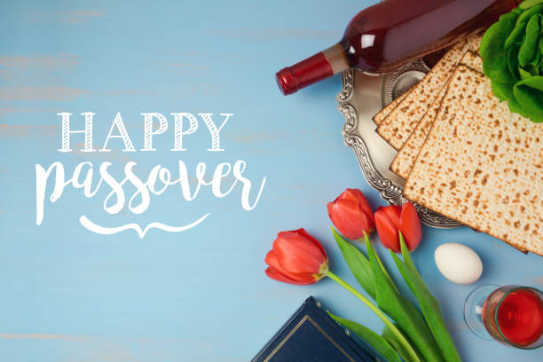 еврейский праздник пасха песах поздравительная открытка с седерной пластиной, мацох и тюльпан цветы на деревянном фоне - passover matzo wine wine bottle стоковые фото и изображения