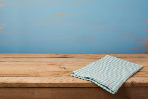 istock Kitchen background with tablecloth on empty wooden table over painted blue wall 831046496