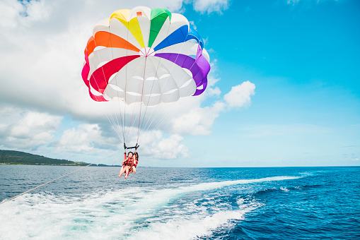 Two women challenging parasailing in Guam