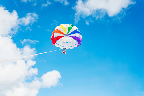 Low angle view of Parasailing against blue sky background