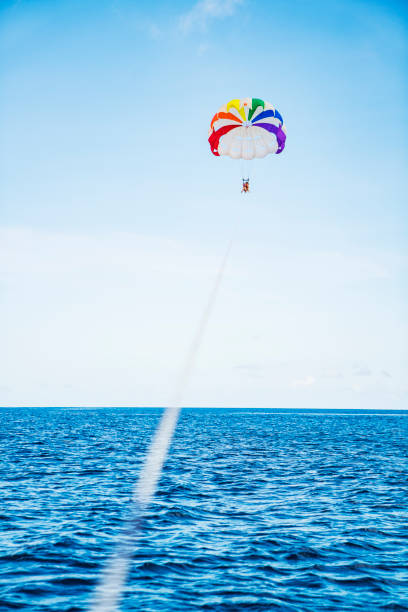 istock Two women parasailing in guam at sunny day 831048736