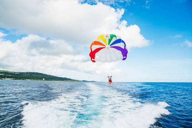 istock Two women parasailing in guam at sunny day 831048754