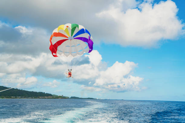 istock Two women parasailing in guam at sunny day 831048764