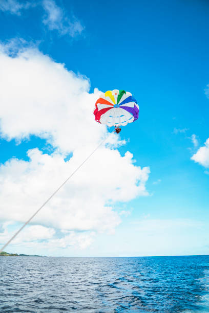 istock Two women parasailing in guam at sunny day 831048768