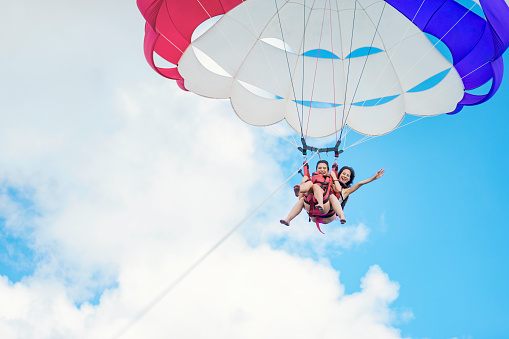 Two women challenging parasailing in Guam