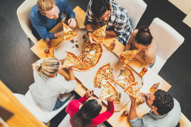 istock Young people eating pizza and drinking cider 831050174