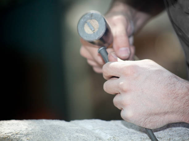 istock Craftsman's hands carving stone. 831050222