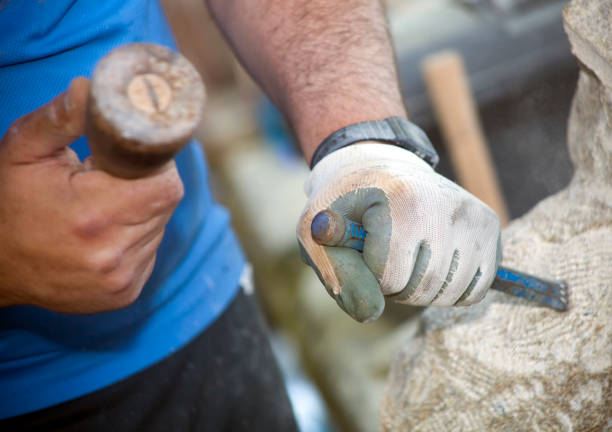 istock Craftsman's hands carving stone. 831050278