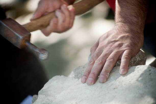istock Craftsman's hands carving stone. 831050296
