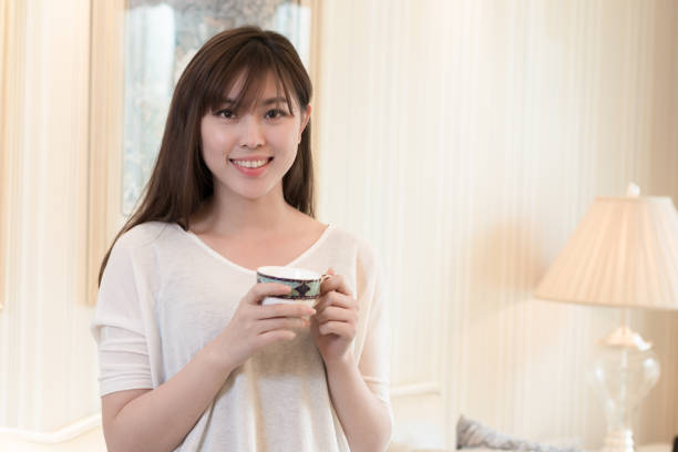 istock young beautiful asian woman with coffee 831053272