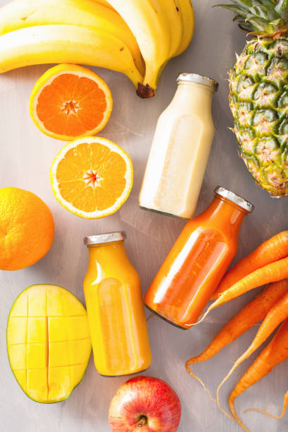 istock fruit and vegetable smoothies in glass jars, orange mango banana carrot pineapple 831060774