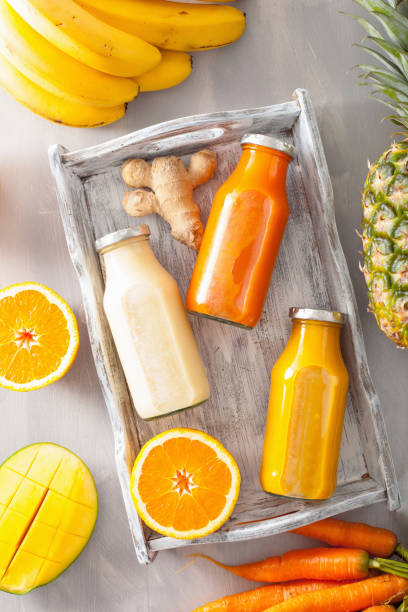 istock fruit and vegetable smoothies in glass jars, orange mango banana carrot pineapple 831060958