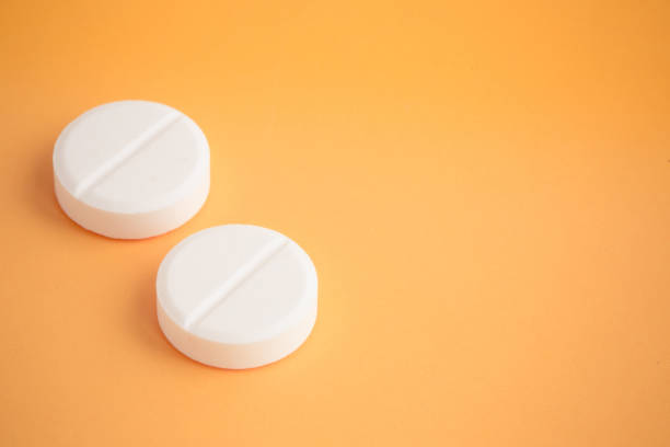 istock WHITE PILLS ON YELLOW BACKGROUND CONCEPT 831061026