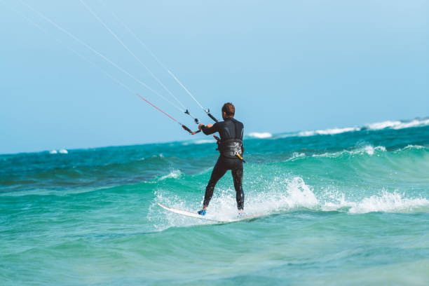 istock Rear view of a kiteboarder standing on kiteboard in blue water 831071464