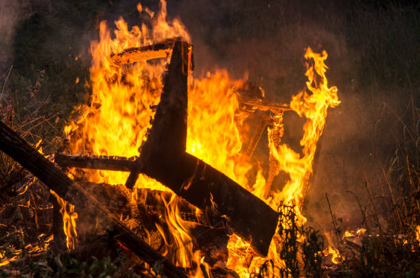 Garbage in fire. Old furniture chair in field. Environment pollution.