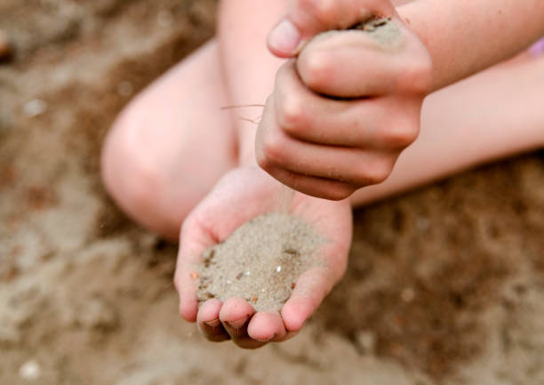 istock Child play with sand in hands. Dry land. 831087640