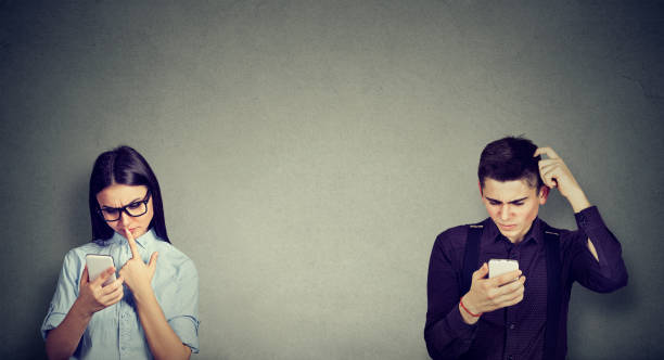 Perplexed young man and woman looking at mobile phone Perplexed young man and woman looking at mobile phone communication problems stock pictures, royalty-free photos & images