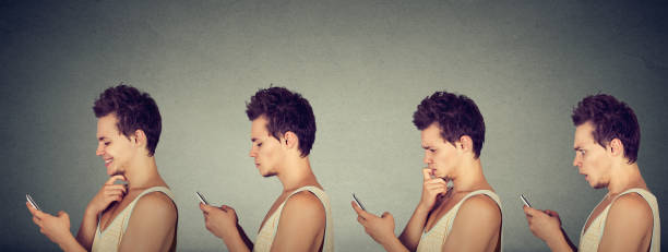 istock Young man expressing different emotions using his mobile phone isolated on gray background 831093510